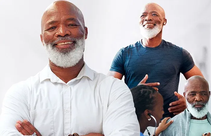 Homem de barba branca sorrindo de braços cruzados